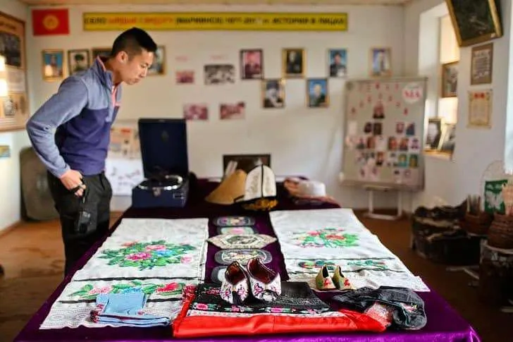 Tourist visiting a Dungan village museum in Karakol region, learning about Dungan heritage and traditional food.